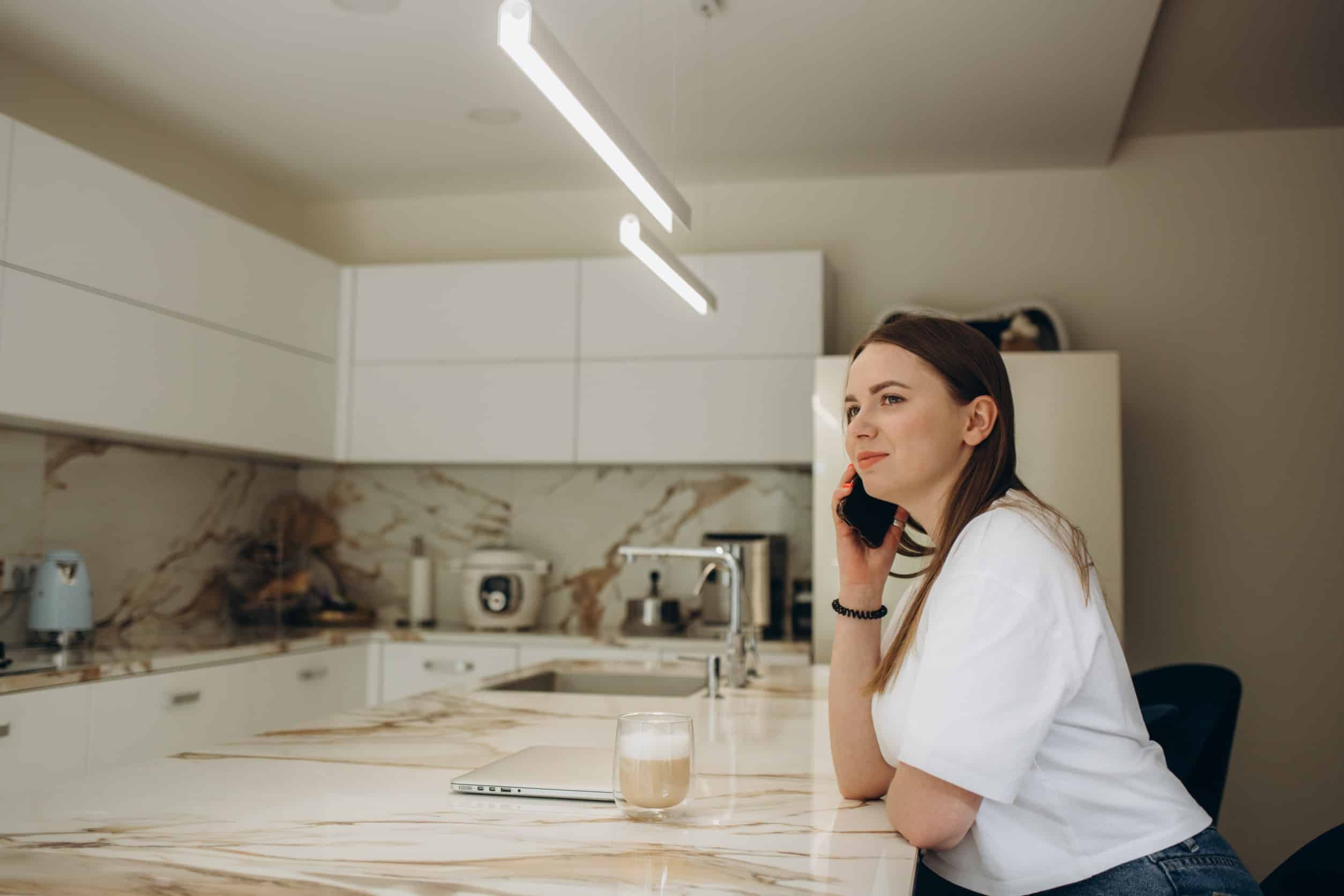 Une femme au téléphone dans sa cuisine